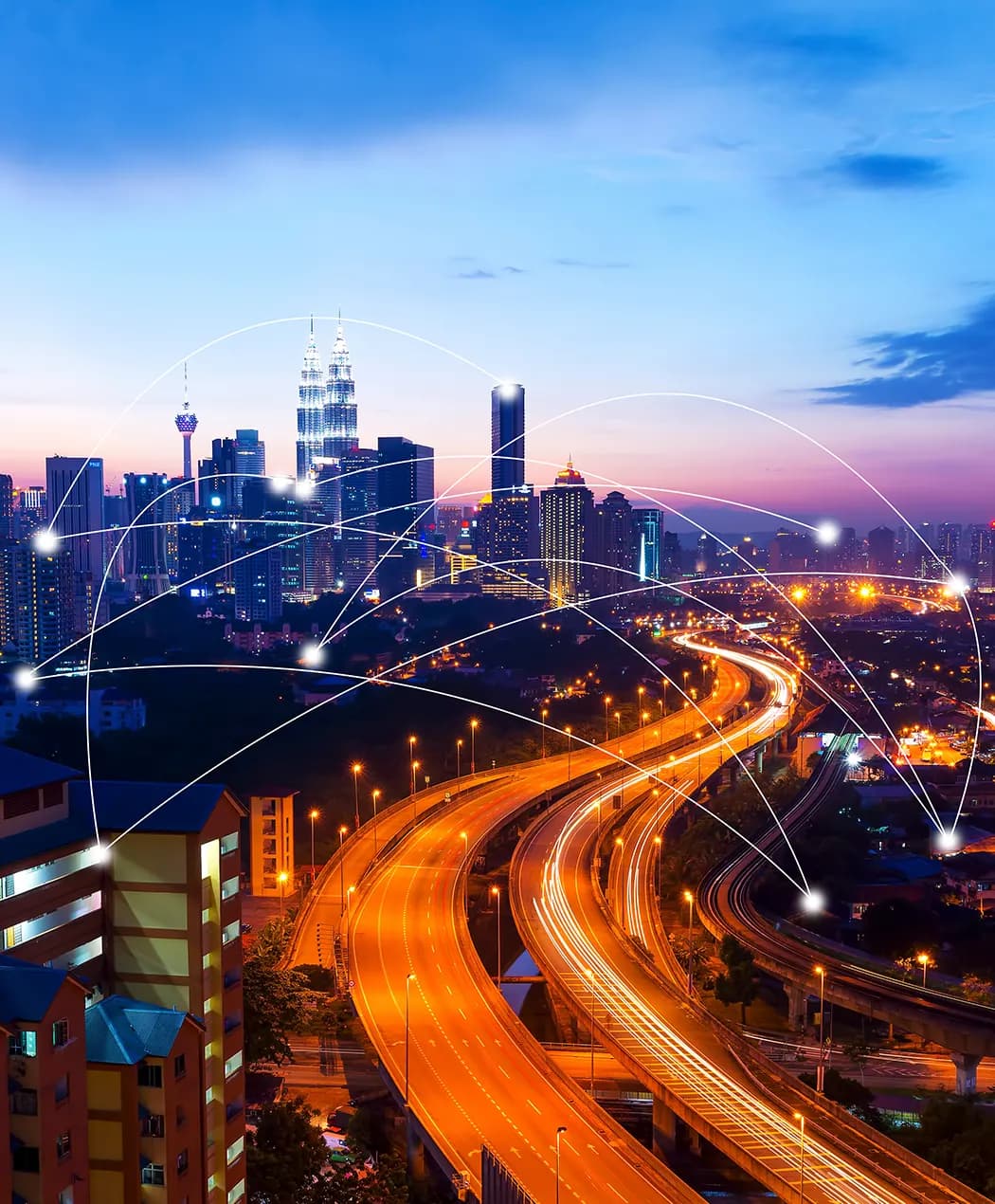 City skyline at dusk with light trails on the highway and network lines connecting points across it