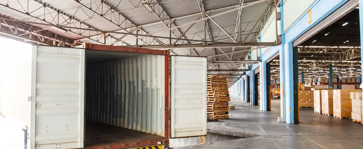 Open trailer backed up to a warehouse loading dock