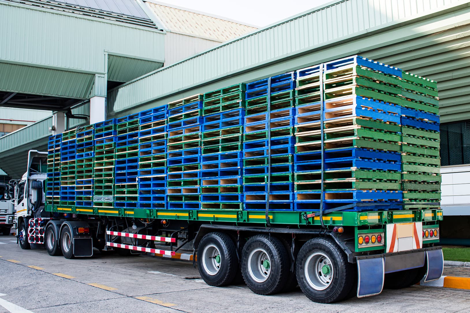 18-wheel truck and trailer hauling 48 x 40 wood pallets on trailer