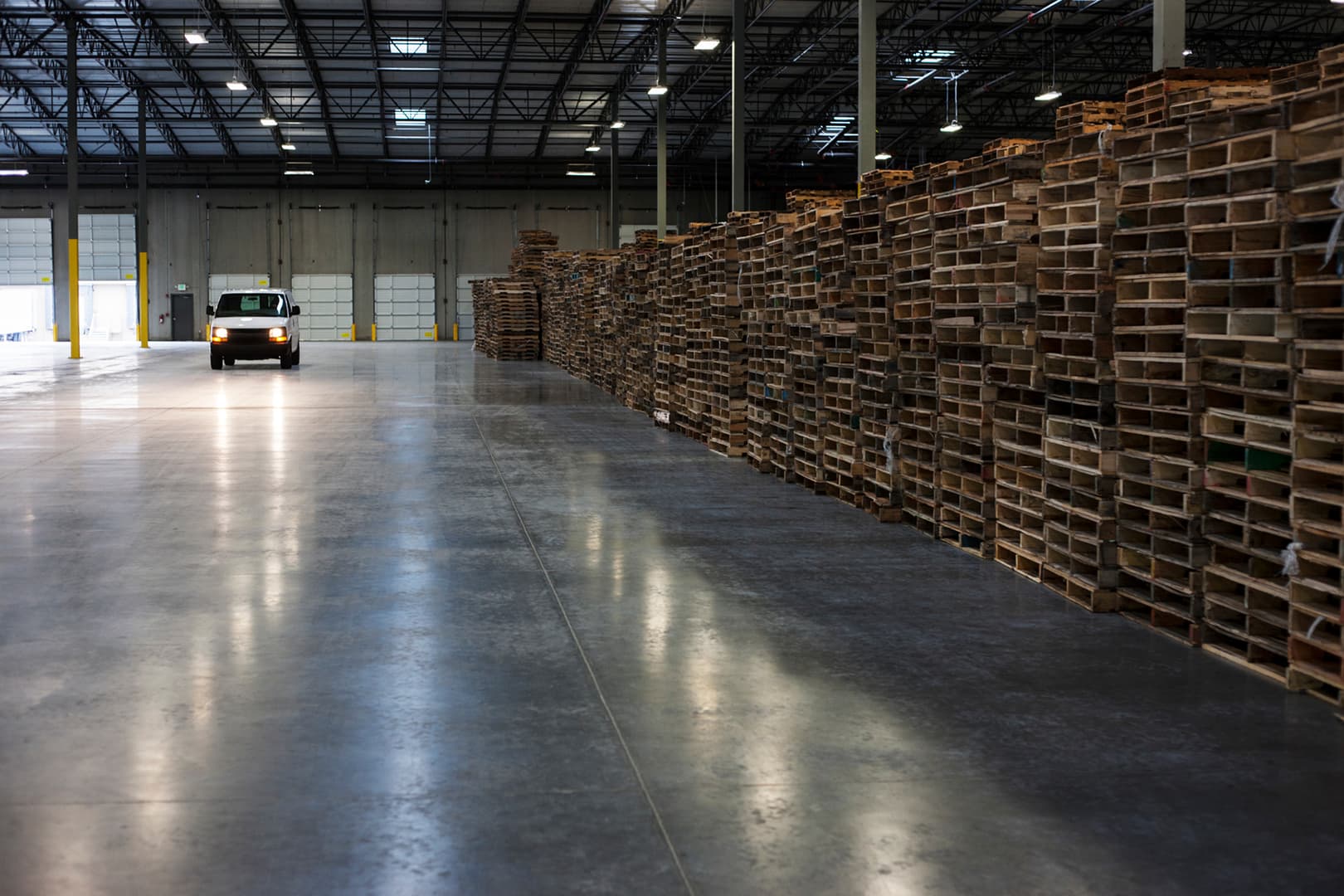 Van inside large warehouse stocked with 48x40 wood pallets