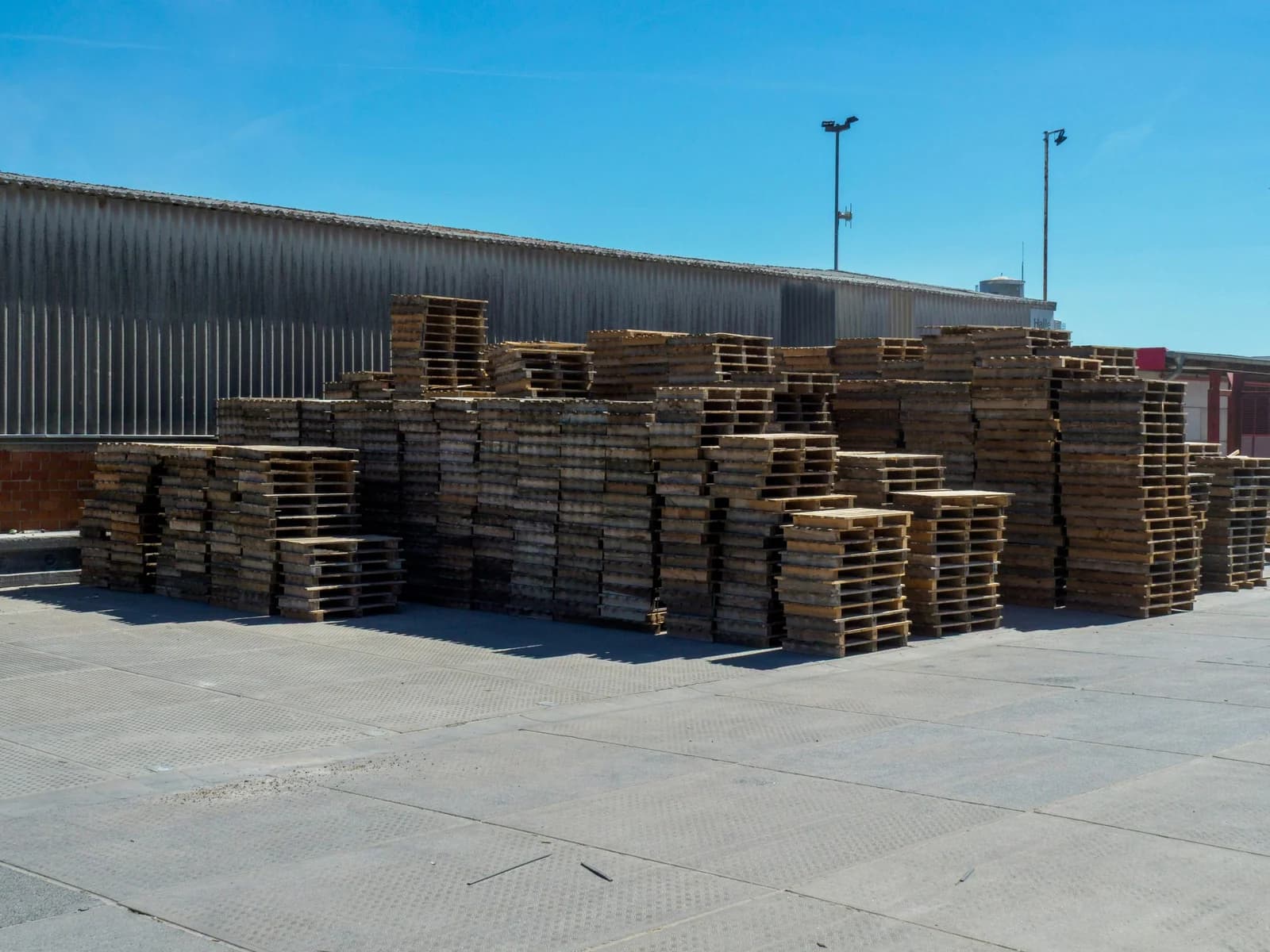a stack of pallets wating to be picked up in a warehouse yard